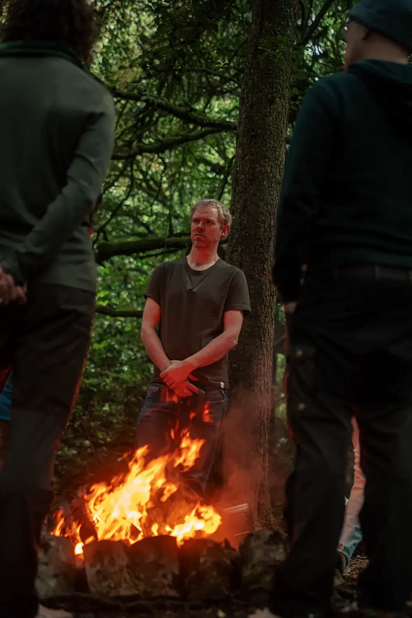 Men standing around a fire in the woods